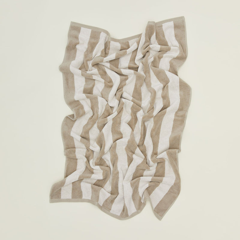 An overhead of a striped light grey and dark grey terry bath towel.